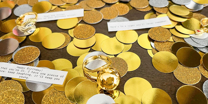 Sphere Secret Ring surrdounded by gold and silver confetti along with fortunes.